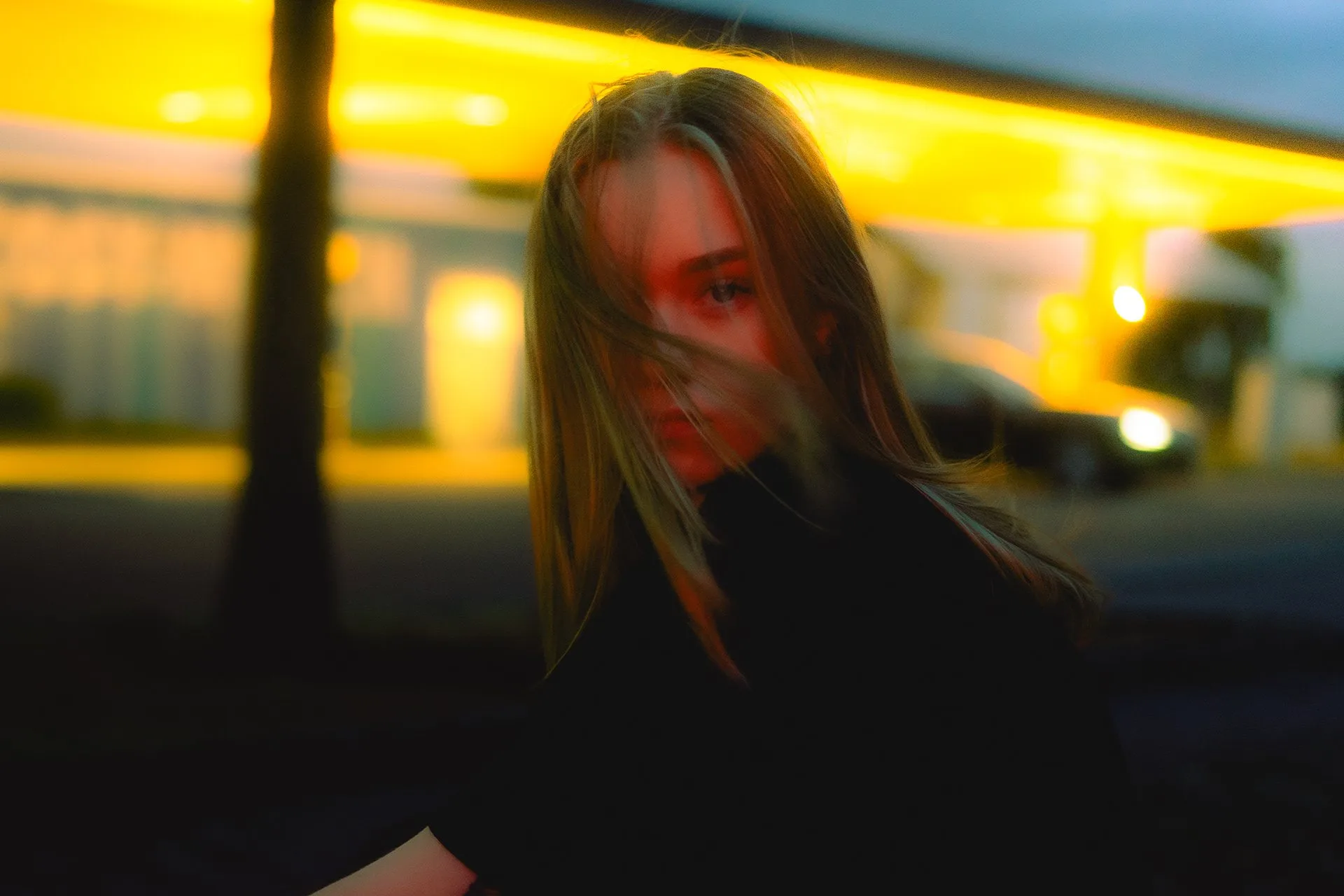 Haare im Wind vor der Tankstelle